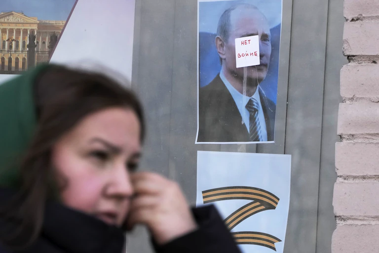 Une femme passe devant une affiche
