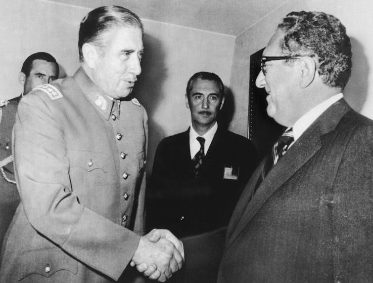 Two men shake hands as they meet.