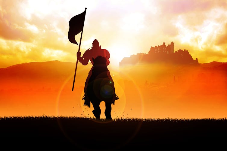 Silhouette of a medieval knight on horse carrying a flag against a sunset background