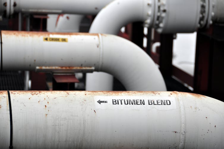Close up of curved pipes with one labelled Bitumen Blend.