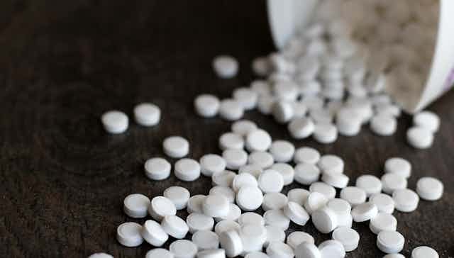 Un pot de pilules d'aspartame a été renversé sur une table noire