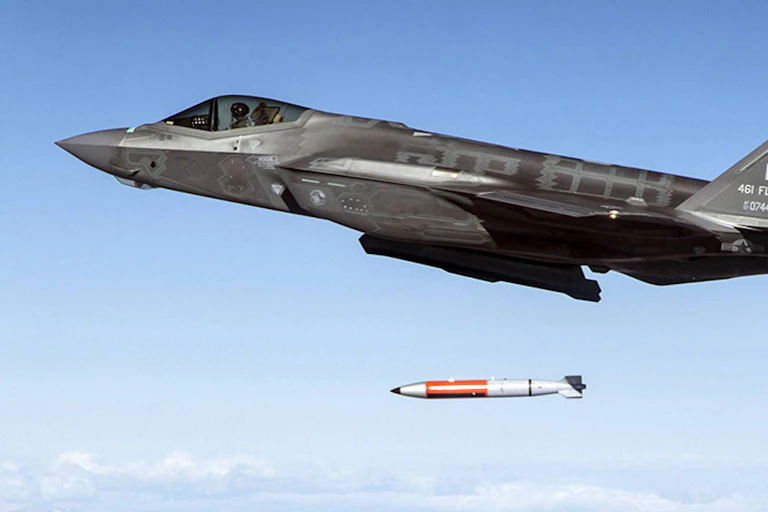 A bomb falls from the bomb bay of an F-35 warplane.