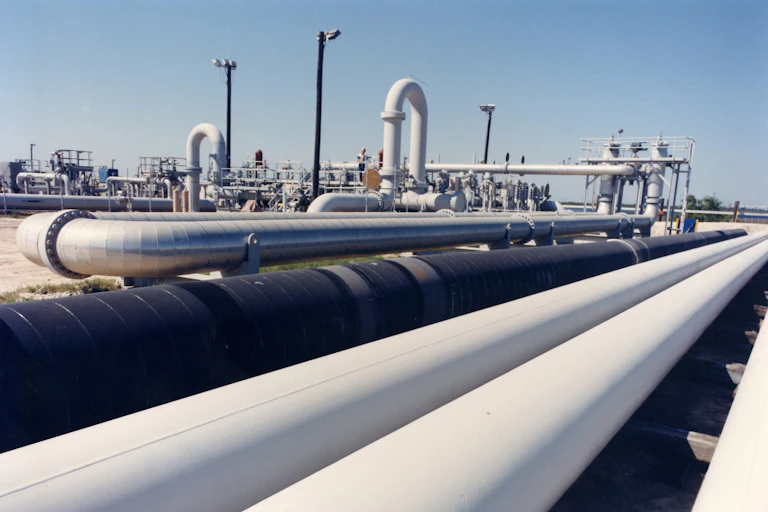 White and black pipes holding oil sit next to other piping gear at an oil repository