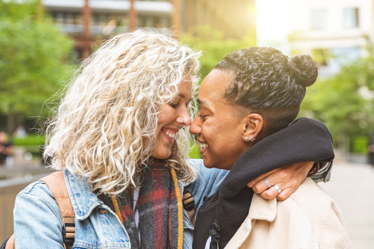 Two women smiling and hugging