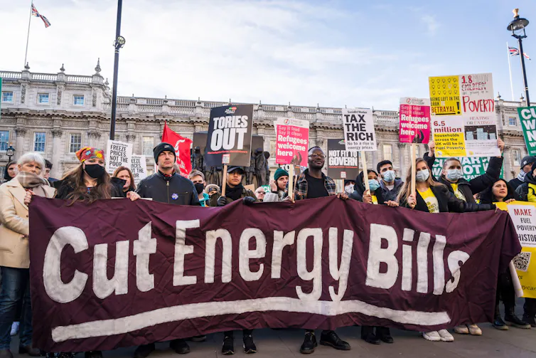 Protesters hold up banner saying 'cut energy bills'
