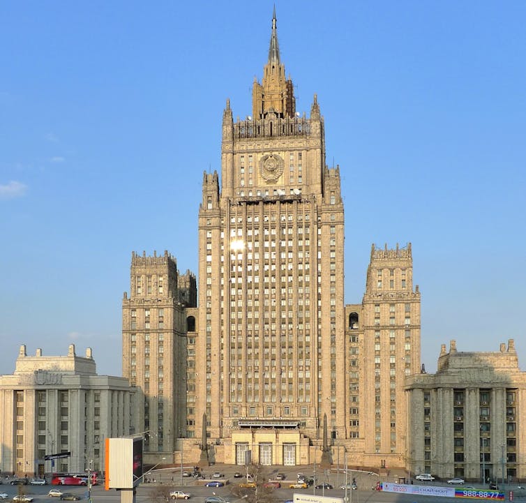 A large multistory building with a clock on its tower facade.