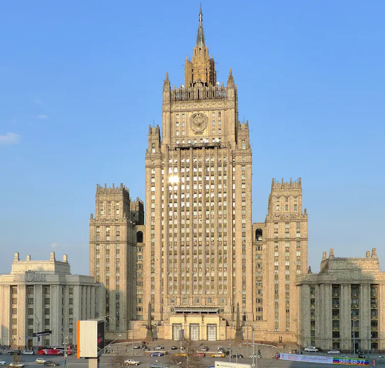 A large multistory building with a clock on its tower facade.