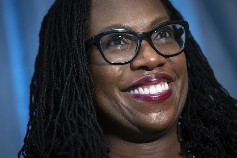Ketanji Brown Jackson wearing glasses smiles broadly.