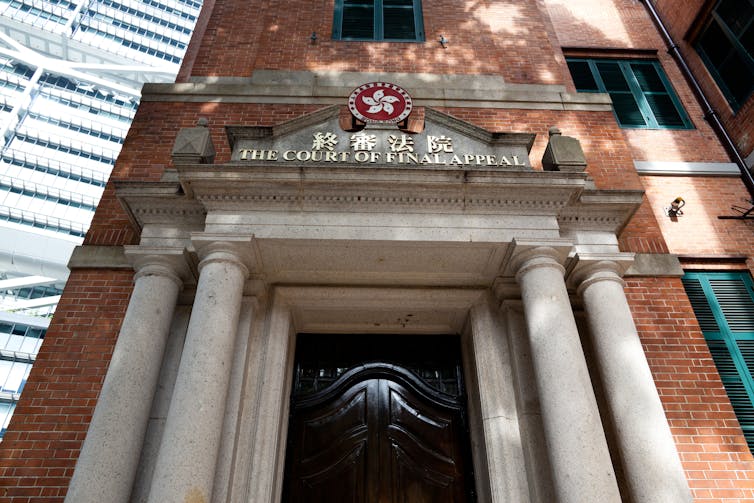 Front facade of the court of final appeal building in Hong Kong, a grand doorway flanked by stone columns