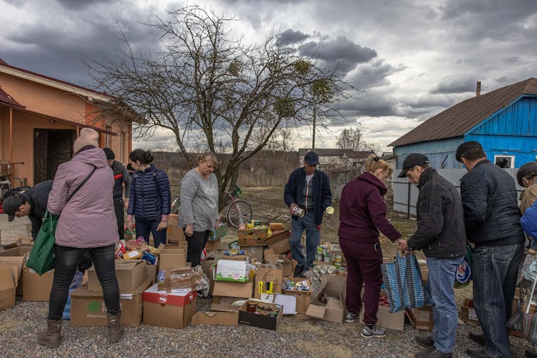 Local residents receive humanitarian aid in the town of Trostyanez. One way to ensure Ukrainians have access to essential supplies is by removing the risky human element, and using drones and driverless cars to deliver aid.