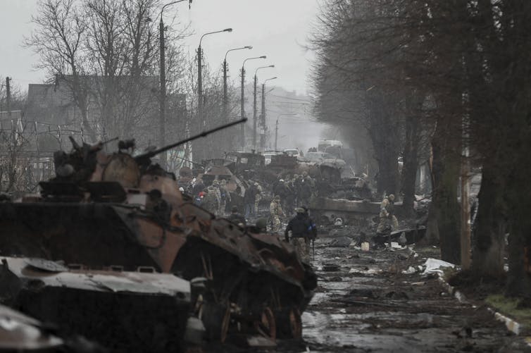 Soldados ucranianos inspeccionan tanques rusos y otros equipos militares abandonados en Bucha, al norte de Ucrania