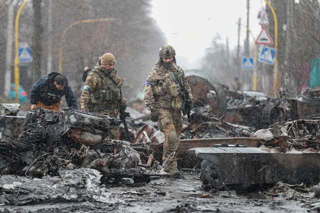 Ukrainians inspect abandoned Russian military vehicles in Bucha, outside Kyiv, April 2022 