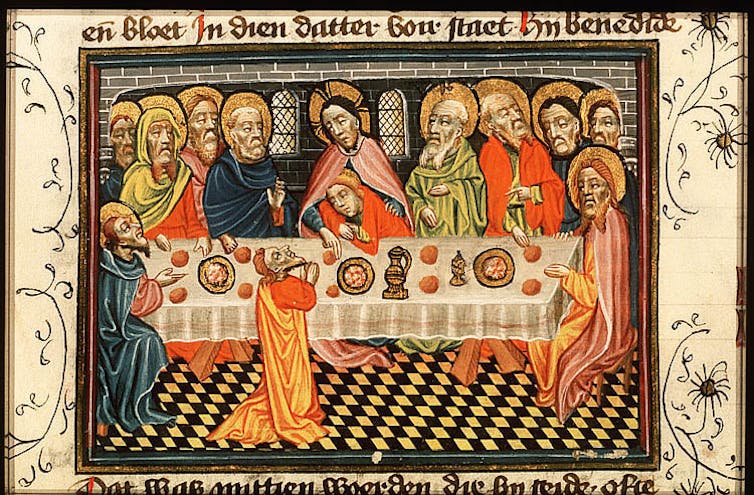 Un manuscrito iluminado de gente comiendo en oro y naranja.