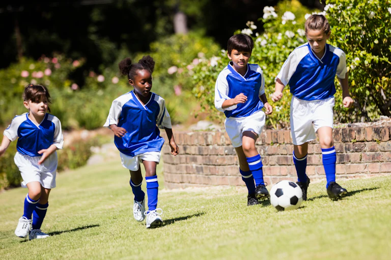 Children in a line playing soccer.
