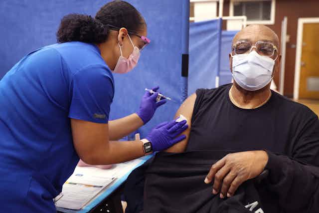 A man at a clinic receives his second booster shot for COVID-19.