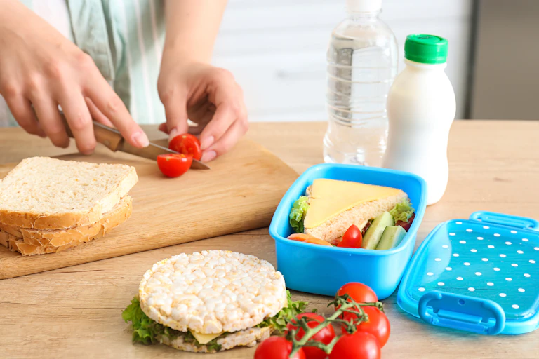 Person cuts tomato to put into lunchbox