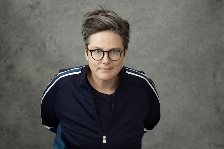A woman in glasses and a tracksuit, facing the camera