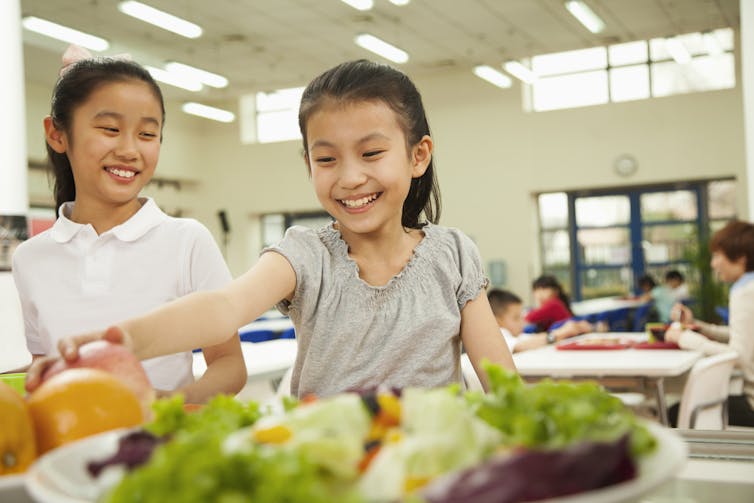 Girl reaches for healthy snack in cafeteria