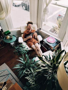 A man strums a ukulele