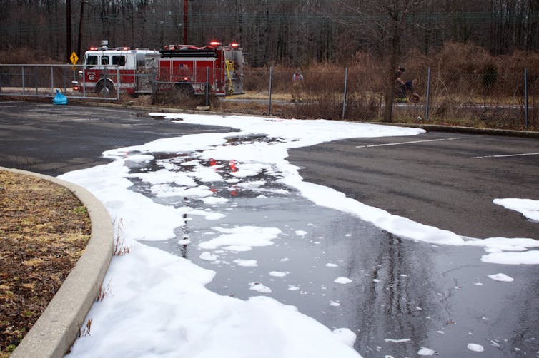 A large puddle of firefighting foam in a street.