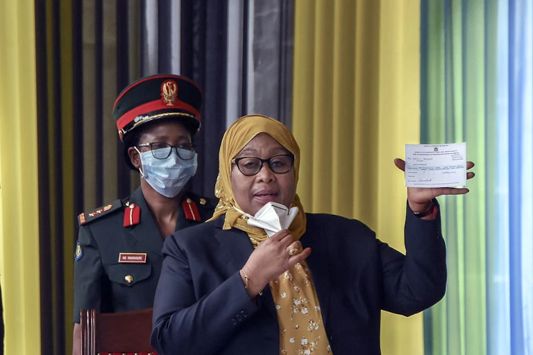 Woman holds up COVID-19 vaccination card