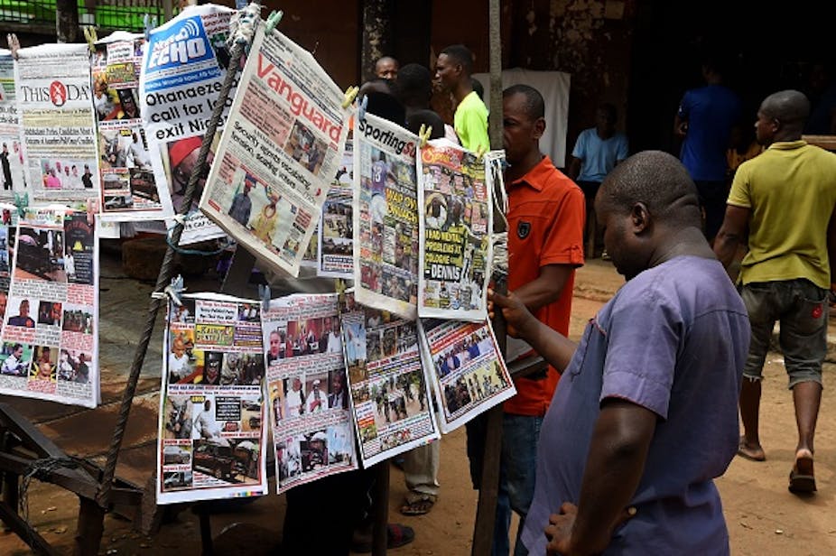 Bystanders read newspapers on a stall in Onitsha, Anambra State, south-eastern Nigeria