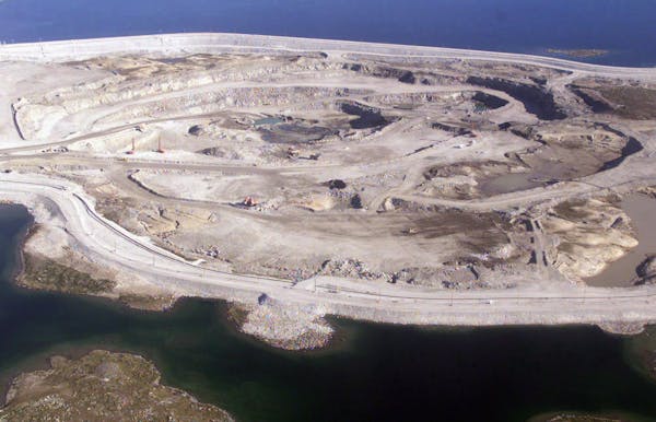 A diamond mine pit with winding roads surrounded by water