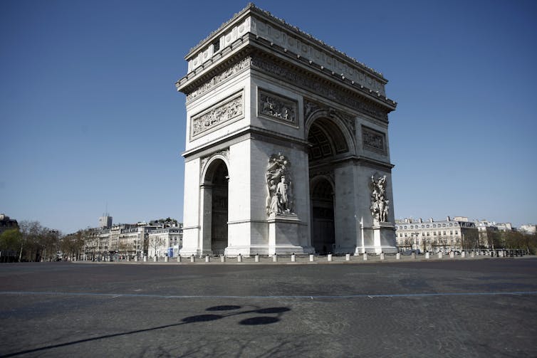 A large square devoid of people with the arc de triomphe in the centre