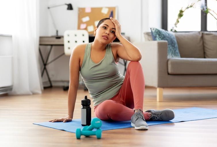 Woman on yoga mat thinking