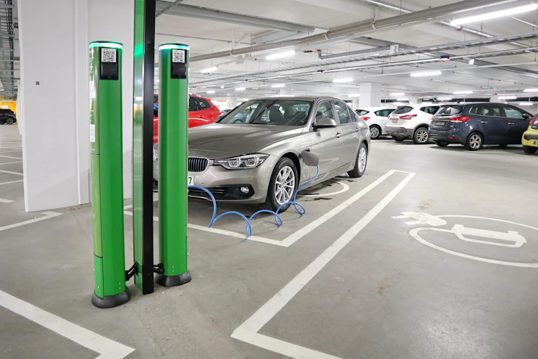 An electric car charging in a car park