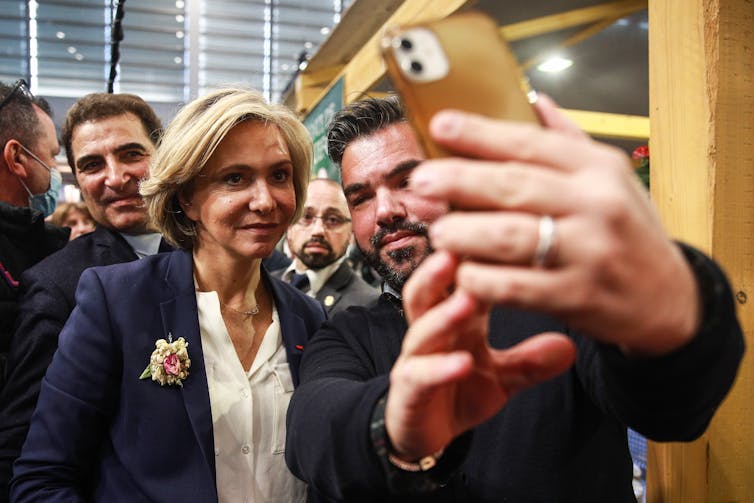 French presidential candidate Valérie Pécresse taking a selfie with a supporter.