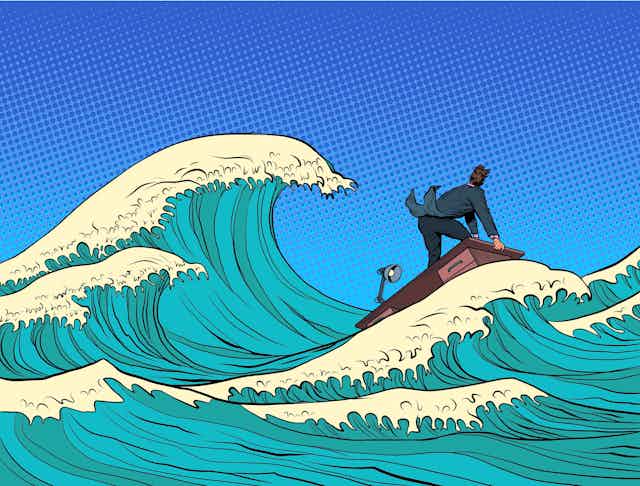 A cartoon depicts a businessman surfing large waves on a desk.