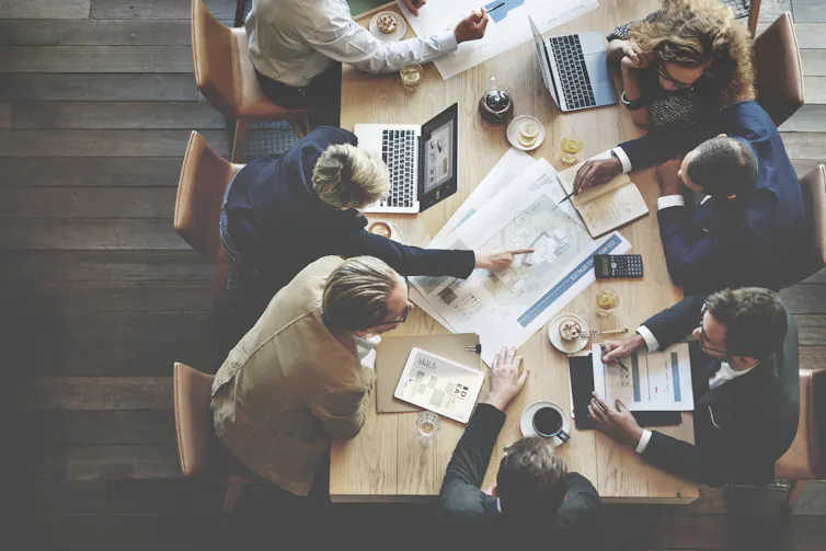 A birds eye view of businesspeople collaborating at a table.