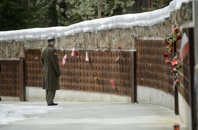 A Polish army officer looks at names on a memorial wall