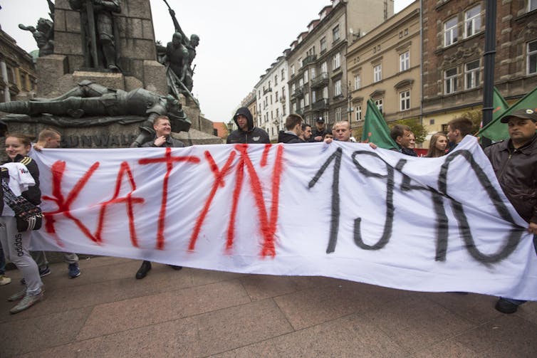People march in Krakow behind a banner reading Katyn 1940.