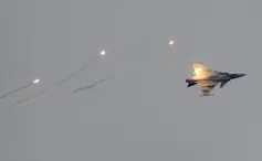 A fighter jet in a greyish sky.