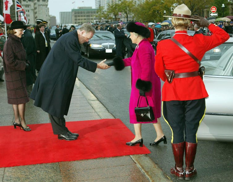 A man bows and puts out a hand