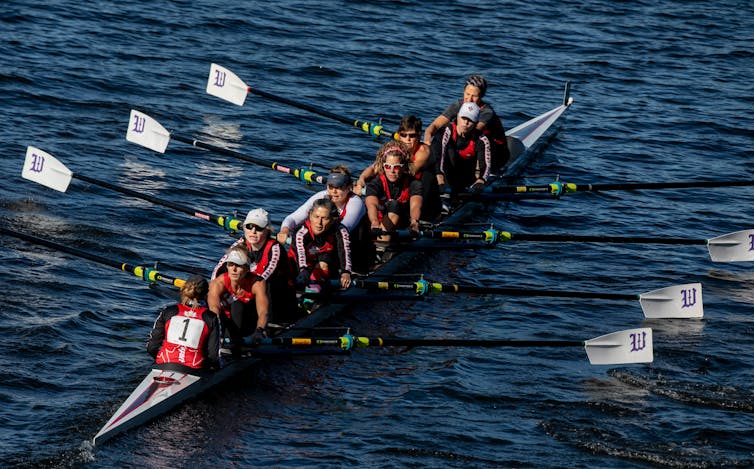 Women competitively rowing in a boat