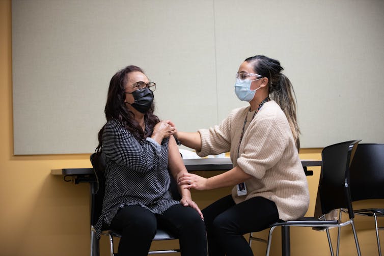 Nisha Yunus, a 64-year old residential care aide in the Vancouver Coastal Health region, receiving her immunisation