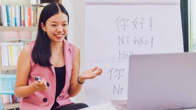Woman in classroom with foreign languages on the blackboard