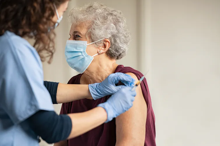 Elderly woman gets vaccinated.