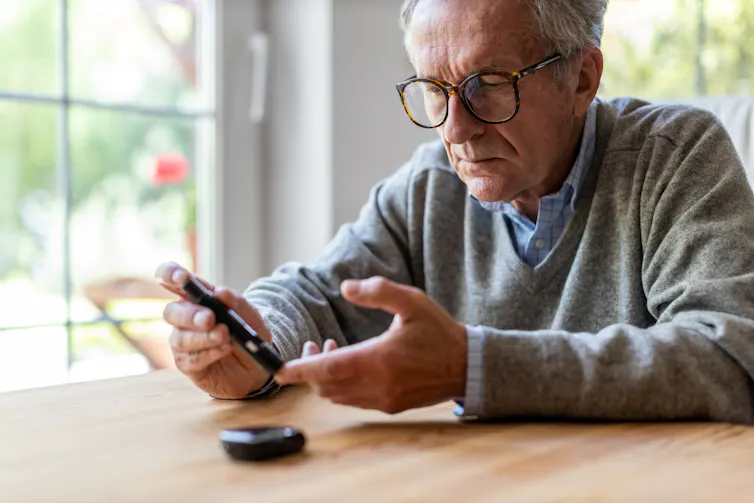 A senior man measuring his blood sugar.
