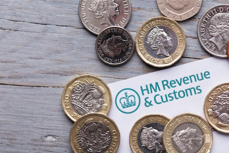 An envelope from HM Revenue and Customs on a table surrounded by pound coins