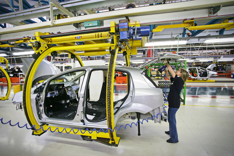 Woman works on engineering automotive vehicle.