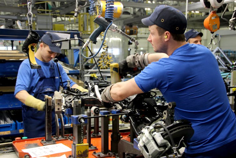 Two men working on automotive engineering.