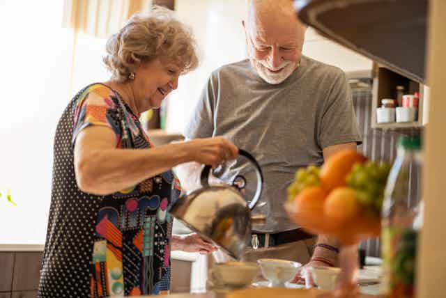 older couple make tea together in kitchen