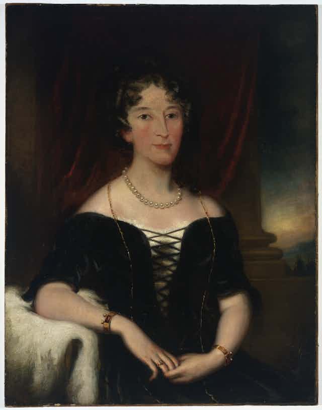 portrait of woman with hair up, curled, and pearls around her neck