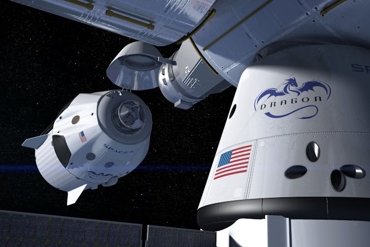A capsule approaches a larger structure in space, marked with a Dragon logo
