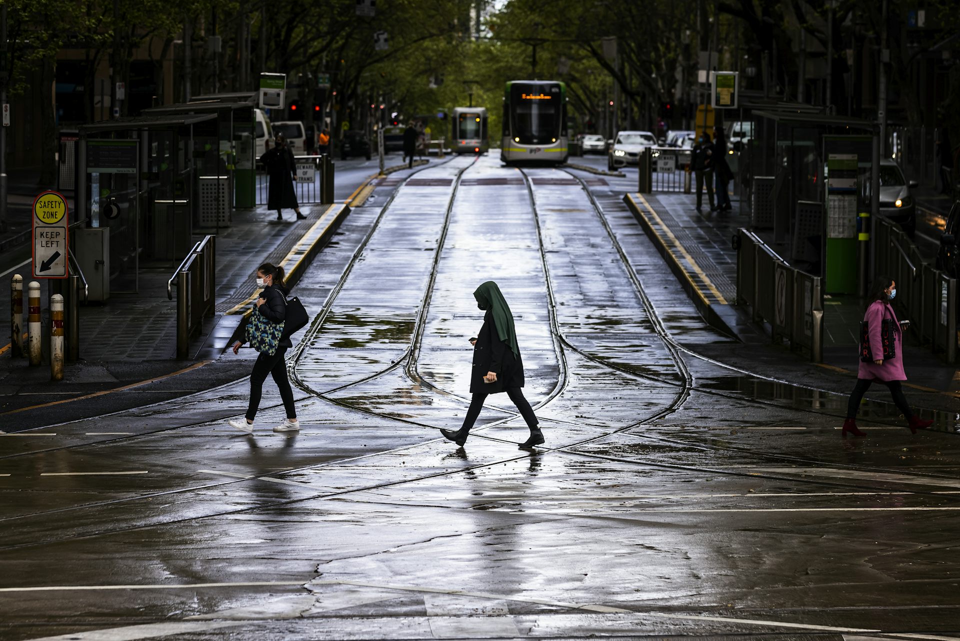 Woman walking alone on Melbourne street with tram in background