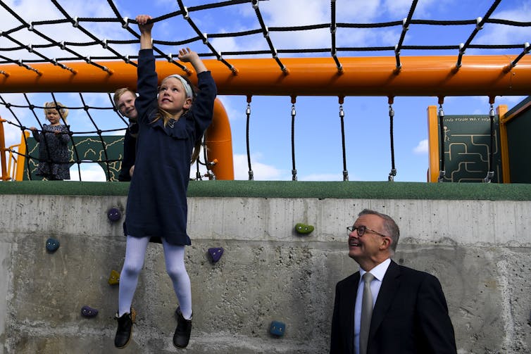 Labor leader Anthony Albanese watches a child climbing.